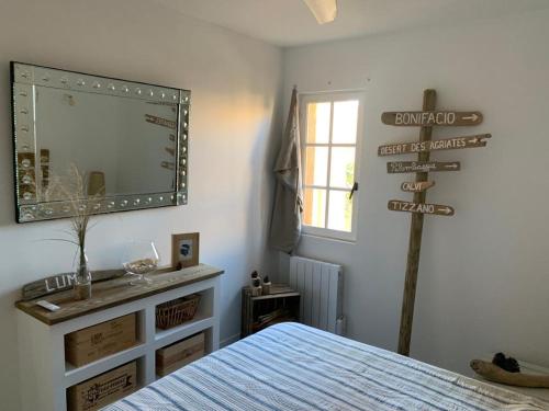 a bedroom with a bed and a mirror and a sign at Bel appartement idéalement situé en Haute Corse in Lumio