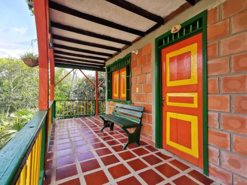 a porch with a bench on a brick building at Finca Hotel Villa Mariana in Montenegro