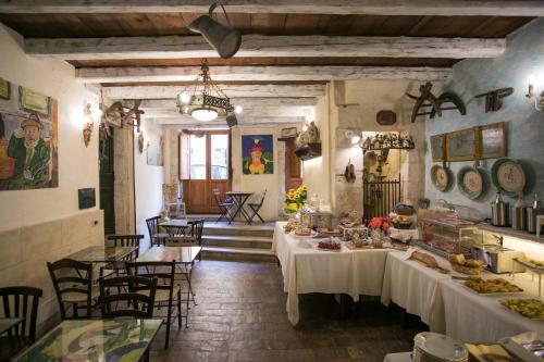 restauracja ze stołami i krzesłami, na których znajduje się jedzenie w obiekcie Hotel Henry's House w Syrakuzach