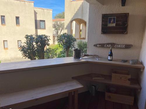 un bancone con una bottiglia di vino e una finestra di Bel appartement idéalement situé en Haute Corse a Lumio