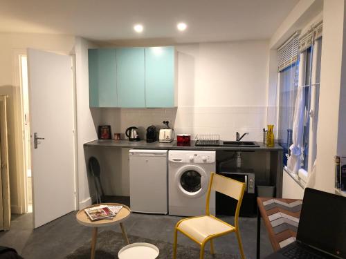 une cuisine avec un lave-linge et un lave-linge dans l'établissement Cité Pilleux - Charming Studio in a flowery pedestrian lane, à Paris