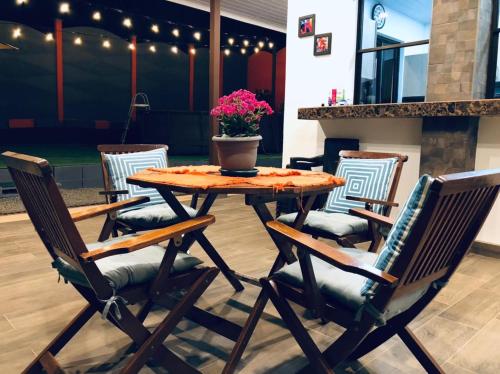 een houten tafel en stoelen met een potplant op een patio bij Casa Leyenda in Arbolito
