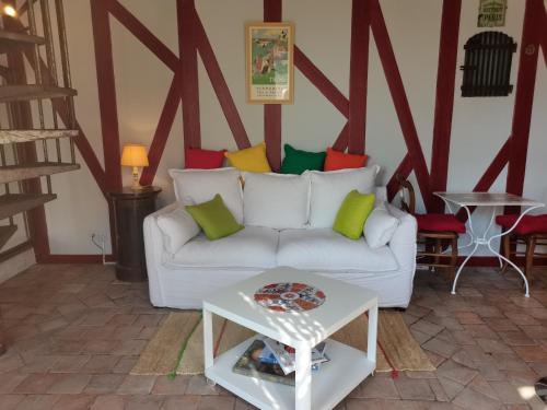 a living room with a white couch and a table at Charmant gîte duplex du bon accueil in Trôo