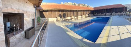 a swimming pool with chairs and a tv on a building at 7 Wonders Hotel in Wadi Musa
