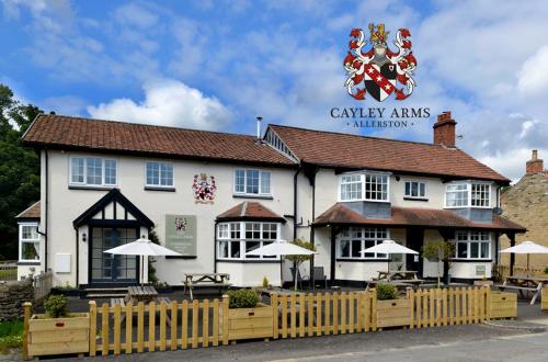 皮克林的住宿－The Cayley Arms Inn，前面有栅栏的白色建筑