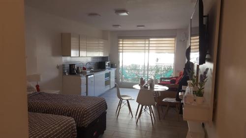 Habitación con cama y cocina con mesa en Cerca de Todo ARG en Buenos Aires