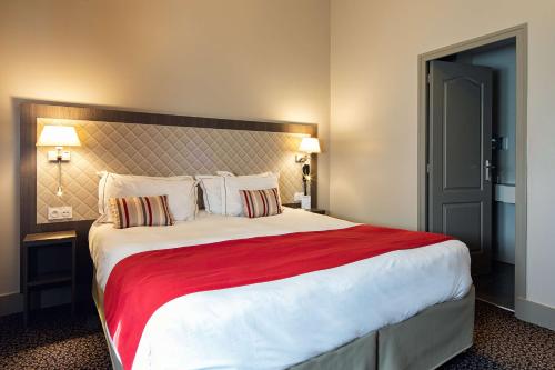 a bedroom with a large bed with a red blanket at Best Western Central Hotel in Tours