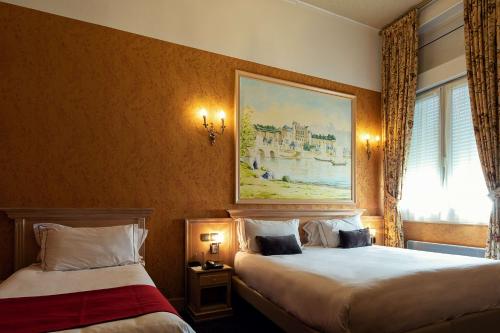 a hotel room with two beds and a painting on the wall at Best Western Central Hotel in Tours