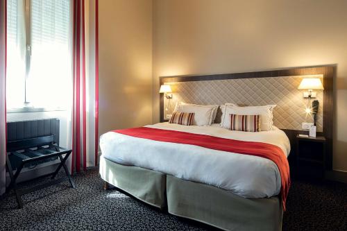 a bedroom with a large bed with a red blanket at Best Western Central Hotel in Tours