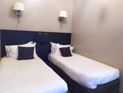 two beds sitting next to each other in a room at Best Western Central Hotel in Tours