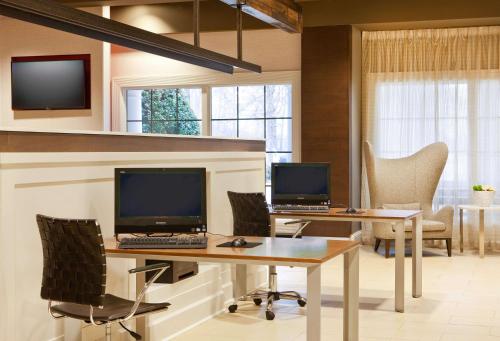 an office with two computers on desks and chairs at Sonesta Atlanta Airport South in Atlanta