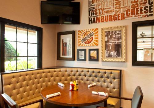 a dining room with a table and a booth at Sonesta Atlanta Airport South in Atlanta