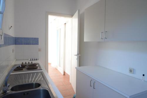 a white kitchen with a sink and a window at Elea Villas Steni Vala Alonissos in Steni Vala Alonissos