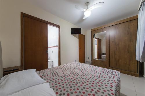 1 dormitorio con 1 cama y puerta de madera grande en Praia do Forte - Condomínio Forte da Praia, en Cabo Frío