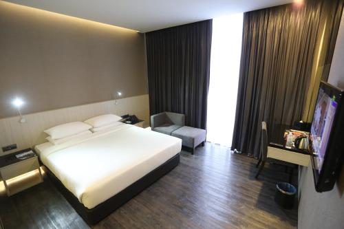 um quarto de hotel com uma cama e uma televisão em e.City Hotel@OneCity em Subang Jaya