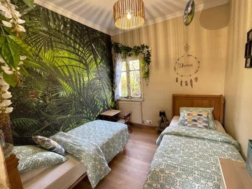 - une chambre avec 2 lits et un mur de plantes dans l'établissement Le Clos des Trois Provinces, Zoo de Beauval, à Noyers-sur-Cher