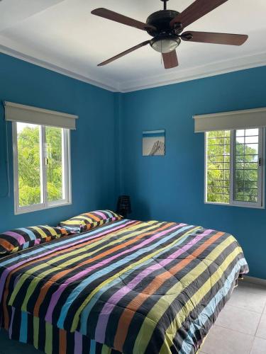 a bed in a blue bedroom with a ceiling fan at Posada Paraiso in El Yaque