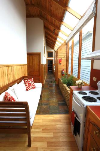 a living room with a couch and a stove at @ the beach & not quite @ the beach Holiday Cottages - Stanley in Stanley