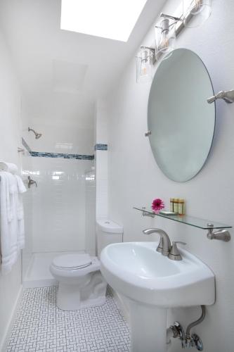 a bathroom with a sink and a toilet and a mirror at Inn on the Russian River in Monte Rio