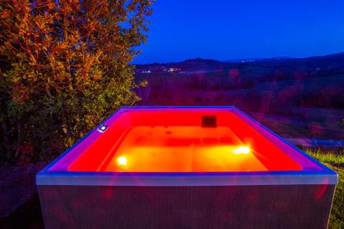 a red bath tub with lights in a field at Terra Antica - Resort, Winery & SPA in Montepulciano
