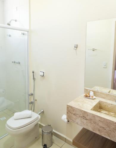 a bathroom with a toilet and a shower and a sink at Village de Charme - 2km do Capivari in Campos do Jordão