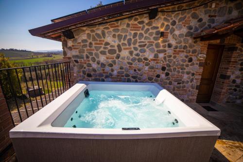 a hot tub in front of a stone building at Terra Antica - Resort, Winery & SPA in Montepulciano