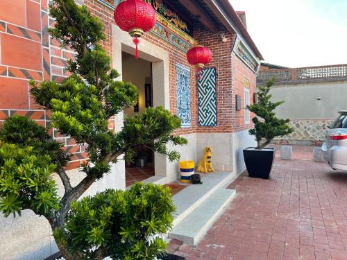 a building with red lanterns on the side of it at 新龍頭古厝行館 Shin Long Tou B&B in Jinning