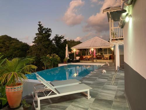 a swimming pool with a lounge chair and a table at Maison Jean in Le Gosier