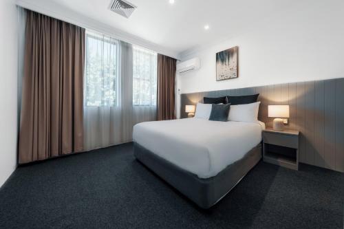 a hotel room with a large bed and a window at The Select Inn Penrith in Penrith