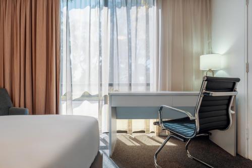 a bedroom with a desk and a chair in front of a window at The Select Inn Penrith in Penrith