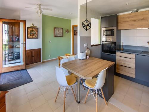 uma cozinha com uma mesa de madeira e cadeiras brancas em Belvilla by OYO Sant Pere Playa em Sant Pere Pescador