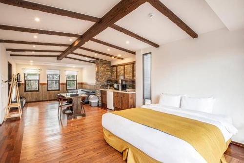 a bedroom with a large bed and a kitchen at Olle Resort in Jeju