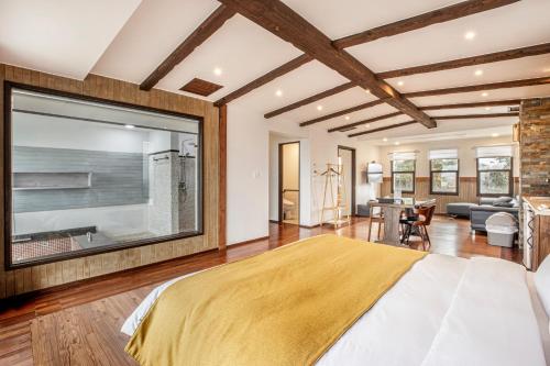 a bedroom with a large window and a living room at Olle Resort in Jeju