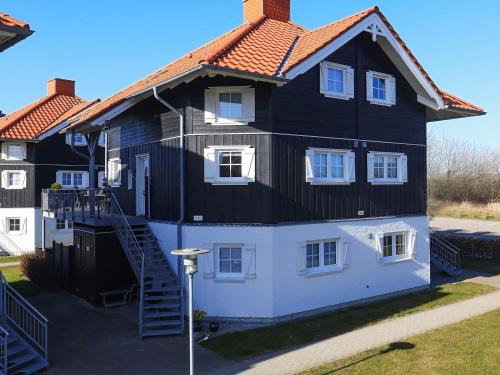a large black and white house with a staircase at 8 person holiday home in Bogense-By Traum in Bogense