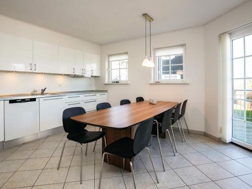 a kitchen with a wooden table and black chairs at 8 person holiday home in Bogense-By Traum in Bogense