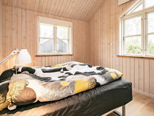 - une chambre avec un lit dans une pièce dotée de murs en bois dans l'établissement Holiday home Hals CX, à Hals