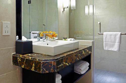 a bathroom with two sinks and a mirror at Amari Dhaka in Dhaka