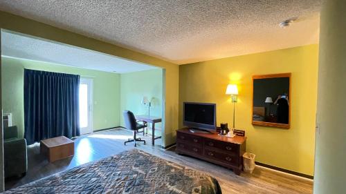 a hotel room with a bed and a television at Harbor Lights Lodge in Kewaunee
