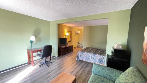 a hotel room with a bedroom with a bed and a desk at Harbor Lights Lodge in Kewaunee