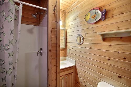 a bathroom with a wooden wall with a toilet and a shower at NC 12 56821-10 Condo in Hatteras