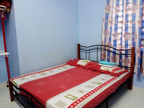 Schlafzimmer mit einem Bett mit einer roten und weißen Decke in der Unterkunft Rumah Tamu Pekan (semi D) in Pekan