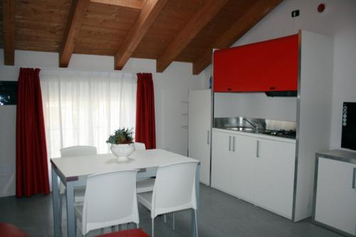 a kitchen with a white table and white chairs at Residenza XX Settembre in Maslianico