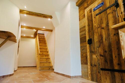 a hallway with a wooden door and stairs at Apart Chalet Unterbrandnerlehen in Schönau am Königssee