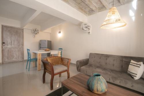 een woonkamer met een bank en een tafel bij Laurdhomes Duplex Old City, Plaza Santo Domingo in Cartagena