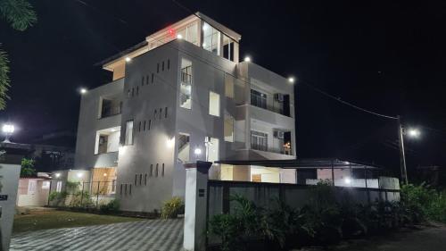 a large white building at night with lights at Grand Station Residence (Rose) in Seeduwa