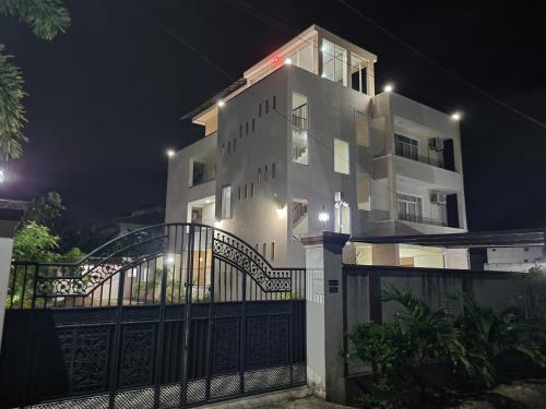 a large white building with a gate at night at Grand Station Residence (Rose) in Seeduwa