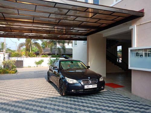 a car parked in a parking lot next to a building at Grand Station Residence (Rose) in Seeduwa