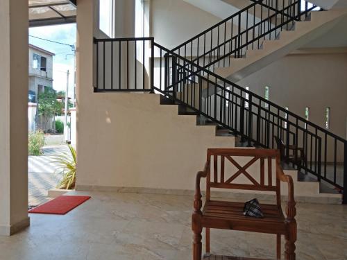 a stairway with a wooden chair in a room at Grand Station Residence (Rose) in Seeduwa