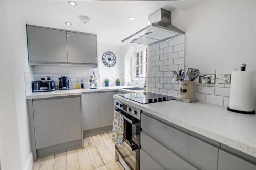 a kitchen with white counters and a stove top oven at Comfy Dales holiday base on Market Place of historic market town in Richmond