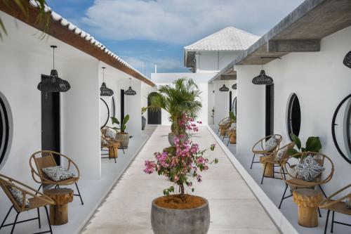 a corridor of a hotel with chairs and plants at Body Factory Bali in Canggu